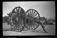 Large wagon wheels on display outside Furnace Creek Camp, Death Valley National Park, 1947