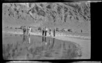 Distant view of Mertie West and Wes Witherby standing beside the pool at Badwater Basin, Death Valley National Park, 1947