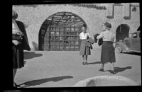 Mertie West poses in front of an arched entry to Scotty's Castle, Death Valley National Park, 1947