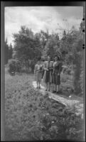 Mertie West and 2 women from Toronto pose on a garden walkway, Banff, 1947