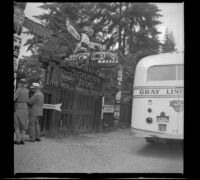 Totem poles stand at the entry gate to the Capilano Suspension Bridge, Vancouver, 1947