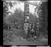 Mertie West and 2 women from Santa Ana pose by a totem pole at Capilano Suspension Bridge Park, Vancouver, 1947