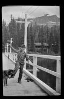 John Johansen stands on a bridge with a trout he caught at Emerald Lake, Yoho National Park, 1947