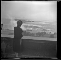 Mertie West views Horseshoe (or Canadian) Falls from behind a parapet, Niagara Falls, 1947