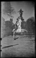 Mertie West poses in front of the statue, "Major General Marquis Gilbert de Lafayette," in Lafayette Square, Washington (D.C.), 1947