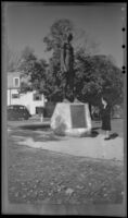 Mertie West stands at the base of "Massasoit," by Cyrus E. Dallin in Cole's Hill and reads the tablet, Plymouth, 1947