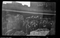 Mertie West poses by produce at a public market, Boston, 1947