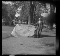 H. H. West poses beside the "Line of the Minute Men" monument in Lexington Common, Lexington, 1947