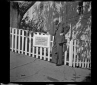 H. H. West poses beside a plaque marking an historical site, Plymouth, 1947