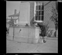 Mertie West drinks from Pilgrim Spring in front of the post office, Plymouth, 1947