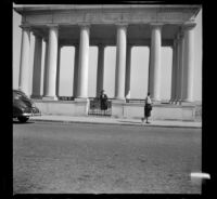 Mertie West stands beneath the portico covering Plymouth Rock, Plymouth, 1947