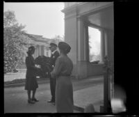 Mertie West at the entrance to the White House listening to a guard and Women's Army Core member in conversation, Washintgon, D.C., 1947