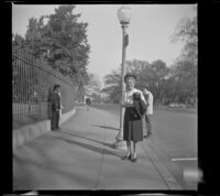 Mertie West at White House fence south side where photographers like to take photos, Washington, D.C., 1947