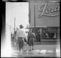Mertie West crosses the street to Lord's store, Atlanta, 1947