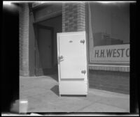 Woodlin electric refrigerator stands on a sidewalk along Omar Avenue, Los Angeles, 1948