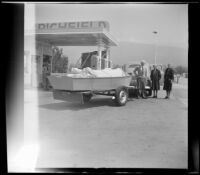 Forrest Whitaker, Mertie West and Agnes Whitaker pose by their boat while stopping for gas en route to Big Bear Lake, San Bernardino, 1948
