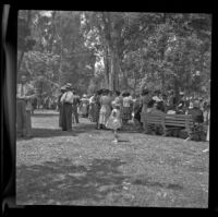 Mrs. Hiatt stands in the Montgomery County section of the Iowa State Picnic and mingles with other attendees, Los Angeles, 1948