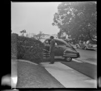 Will Witherby stands beside a car outside Zetta and Dode Witherby's residence, Los Angeles, 1948