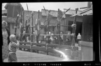 Tiki masks and skulls at the entrance gate to Adventureland at Disneyland, Anaheim, 1957