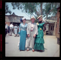 Wayne West between 2 ladies in gay 1890s dresses at Knott's Berry Farm, Buena Park, 1957