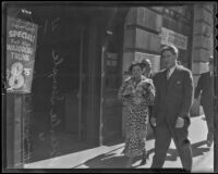 Roberta Semple walking down a commercial street with Jacob Moidel, Los Angeles, 1936