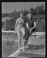 Classmates Betty Baker and Sarah Ann (aka Tay) Ott pose by the side of a swimming pool, Los Angeles, 1936 (?)