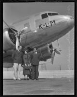 Bob Scholte, KLM pilot, Marjory Gage, aviatrix, and Henrik Veenendaal, KLM representative, stand under a KLM airplane, 1936