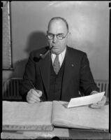 Bert Wallis, police captain, smoking pipe and writing, Los Angeles, 1936