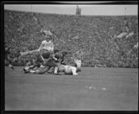 Trojan quarterback, Mickey Anderson, watches as Duke's defenders tackle his teammate, Pasadena, 1939