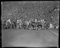 Duke quarterback, Bob Spangler, runs into Trojan linemen during the Rose Bowl, Pasadena, 1939