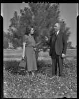 Lois Sprich and Mayor Gus Peterson stand in a garden park, Redlands, 1938