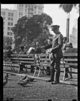 Gerry Cooke, Western Union messenger, is dispatched to feed pigeons in Pershing Square, Los Angeles, 1938