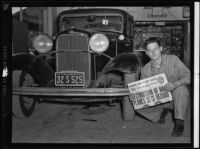 Mechanic poses with Alfred Wells' getaway car, Las Vegas, 1941