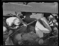 Overhead view of rescuers trying to access a wrecked vehicle, [between 1920-1939]
