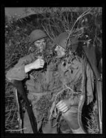 Two Marines stand camouflaged in the brush during a training exercise, Camp Pendleton, circa 1943