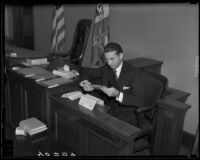 Ralph "Walter" Emerson looks at documents while on the witness stand, Los Angeles, circa 1935