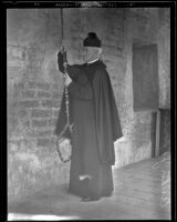 Father Arthur J. Hutchinson rings a church bell, San Juan Capistrano vicinity, circa 1930s