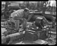 Man reading a gas gauge in an oil field, California, circa 1931
