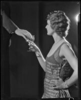 Photograph of a woman taking a goblet of water from a man's hand, Los Angeles, 1935