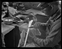 Technician engraving the bell of a brass horn at the F. E. Olds and Son plant, Los Angeles, 1933-1939