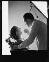 Dentist treating patient in a photograph taken for Sunkist dental, 1935