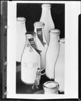 Blindfolded woman among giant bottles of Adohr milk