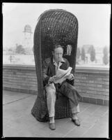 Ted Koehler, lyricist, composer, reading music on a terrace at the Ambassador Hotel, Los Angeles, circa 1933
