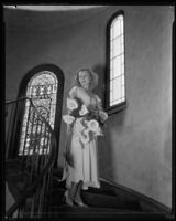 Evalyn Knapp, actress, posing on a spiral stair case, circa 1932-1934