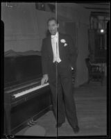 Michael Bartlett, baritone and actor, beside a piano, 1935