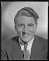 Man wearing a jacket and tie and smiling, circa 1926-1939