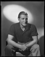 Man sitting forward with his hands clasped, circa 1926-1939