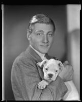 Man holding a puppy, circa 1926-1939