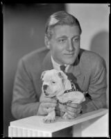 Man holding on to a puppy, circa 1926-1939
