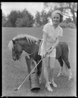 Inez Courtney, actress, swinging a golf club with a pony behind her, circa 1934-1939